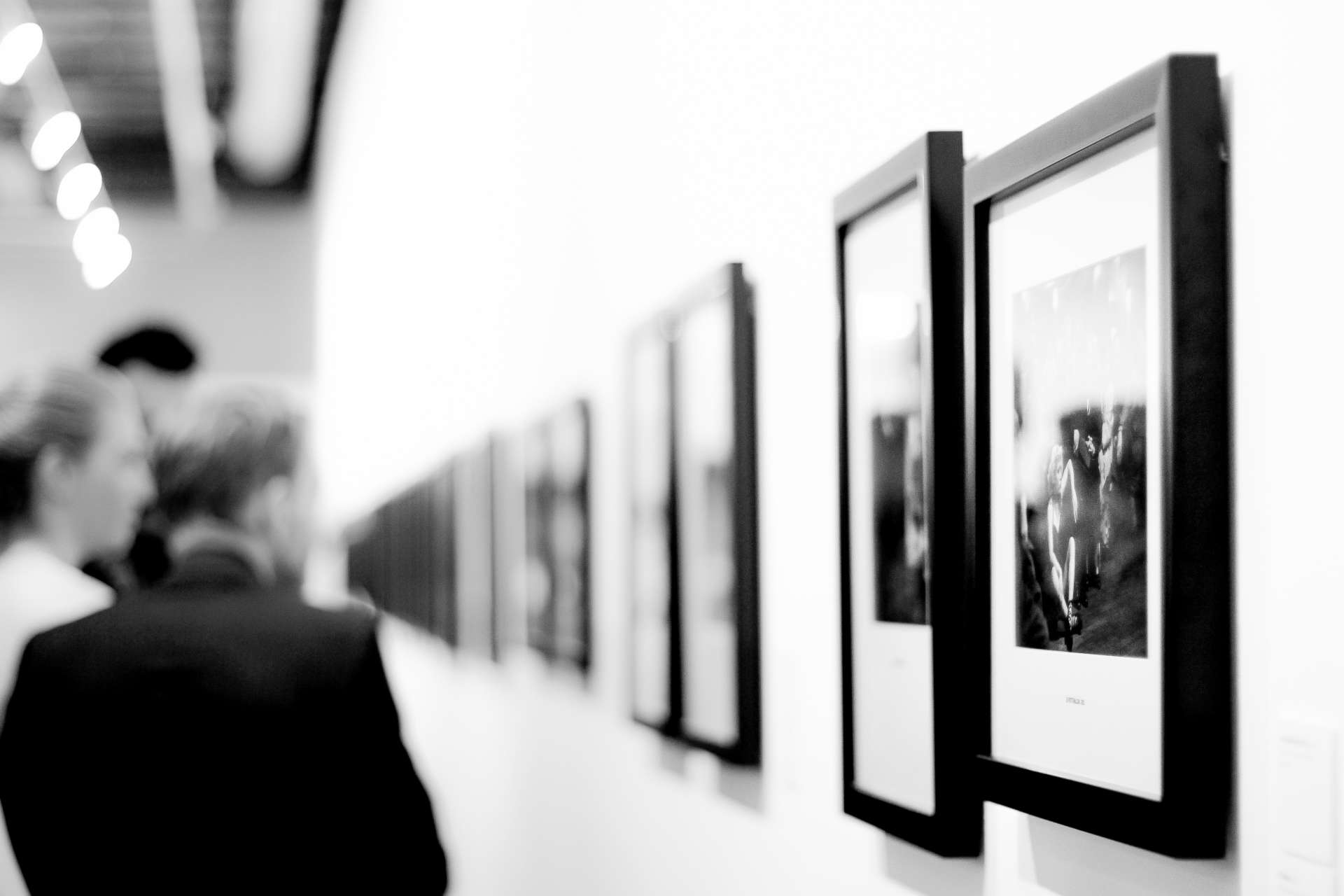 people viewing photographs at an art exhibit