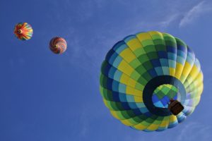 Three hot air balloons soaring in a cloudless blue sky
