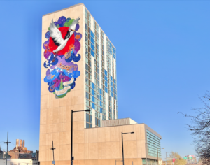 A colorful wall mural on the side of The Crane Apartment building, showing a crane soaring upwards with paper cranes and peony petals by Artist Chenlin Cai.