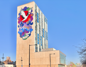 A colorful wall mural on the side of The Crane Apartment building, showing a crane soaring upwards with paper cranes and peony petals by Artist Chenlin Cai. 